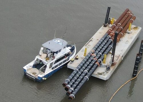 Workboat towing barge with cargo for marine piling operations in the Port of Cairns, Queensland - North Marine vessel charters